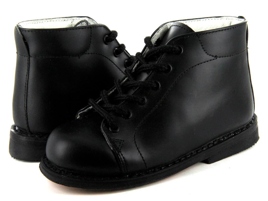Par de botines negros de cuero para niño con agujetas negras y suela resistente sobre fondo blanco.