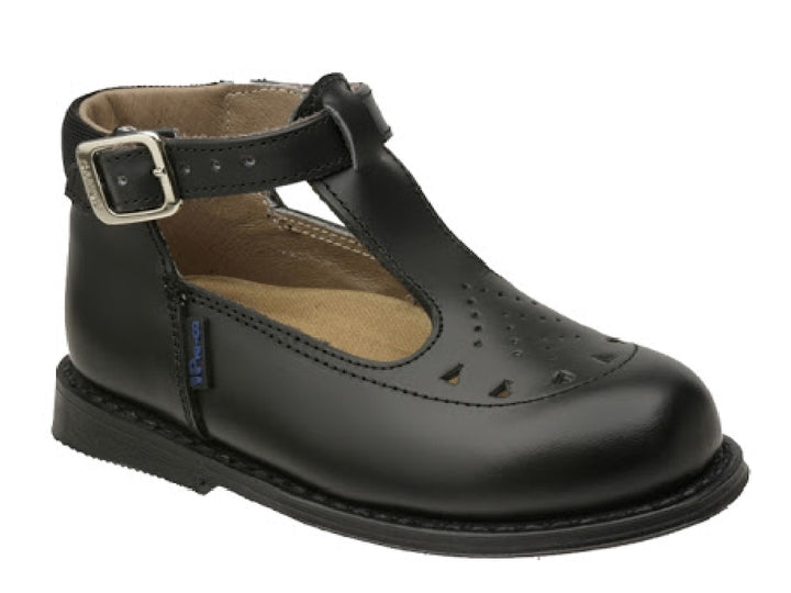 Zapato negro de cuero para niño o niña con correa, hebilla plateada y detalles perforados en la punta.