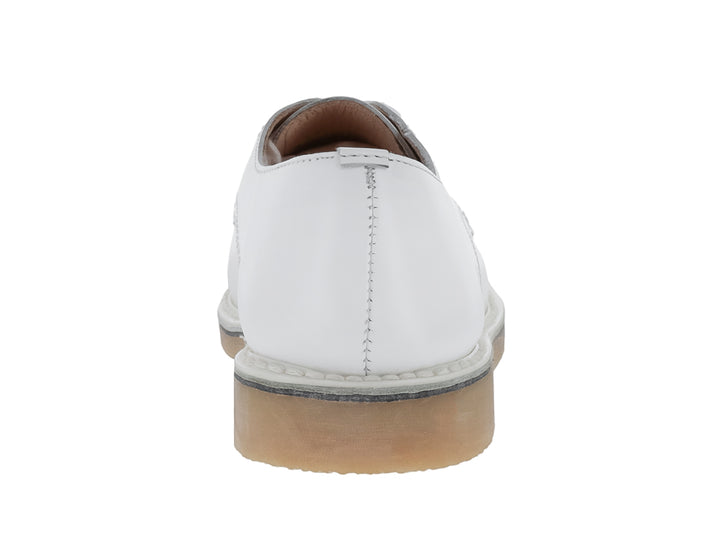 Zapato escolar color blanco para niño con cordones y suela beige.