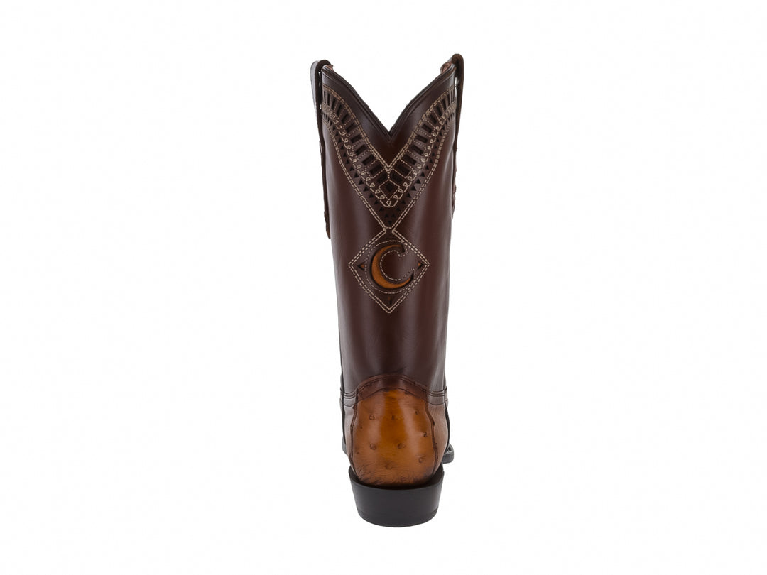 Bota vaquera de cuero color brandy con detalles bordados y punta picada sobre fondo blanco.