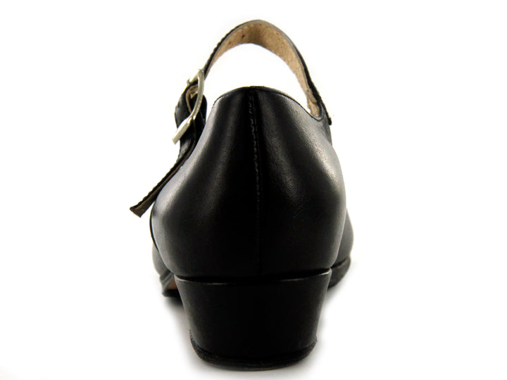 Par de zapatos negros infantiles con correa y hebilla plateada sobre fondo blanco.