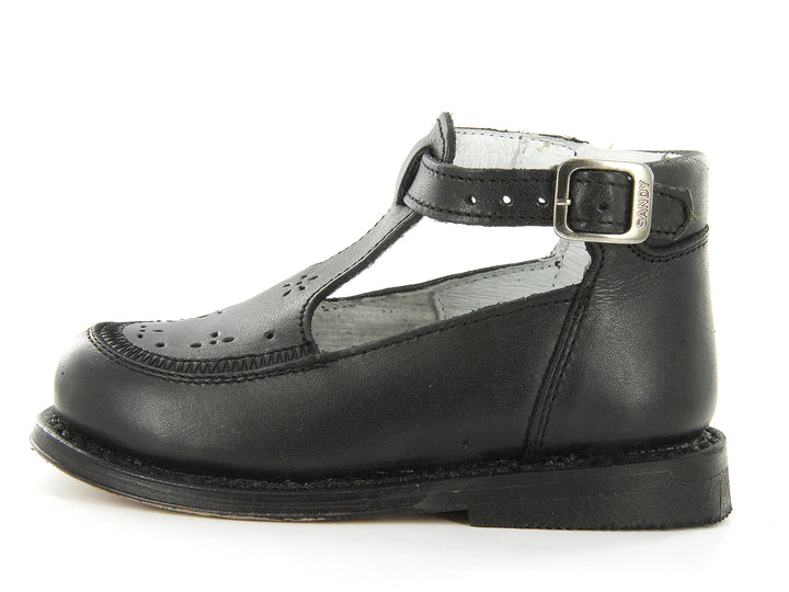 Par de zapatos negros clásicos para niño con correa y hebilla metálica sobre fondo blanco.
