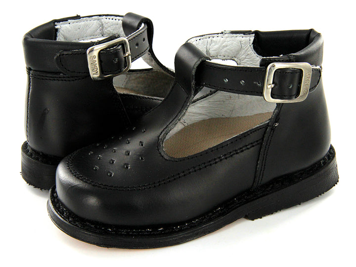 Par de zapatos negros para niño con correa y hebilla plateada, estilo clásico escolar.