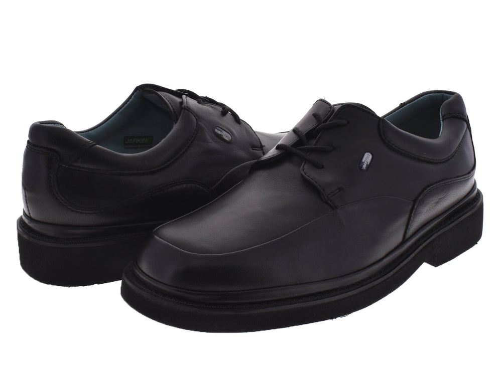 Zapato formal color negro para niño con cordones y suela robusta sobre fondo blanco.