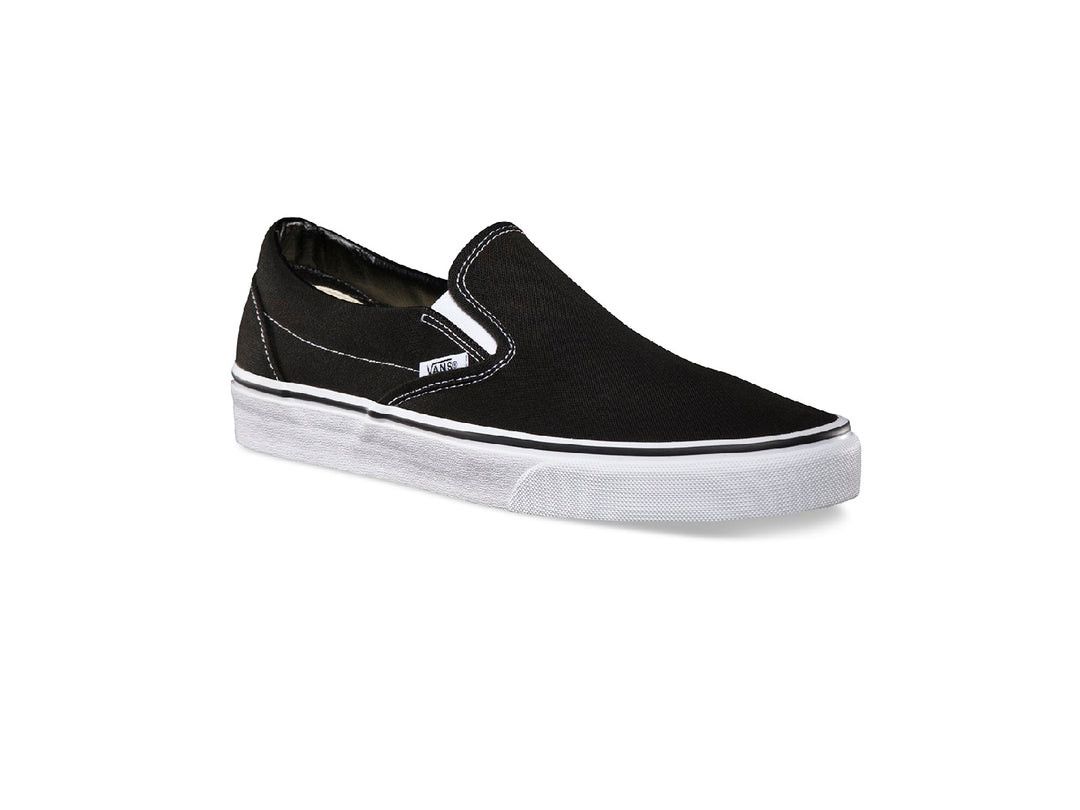 Tenis Vans Classic Slip-On color negro con suela blanca y diseño sin cordones.