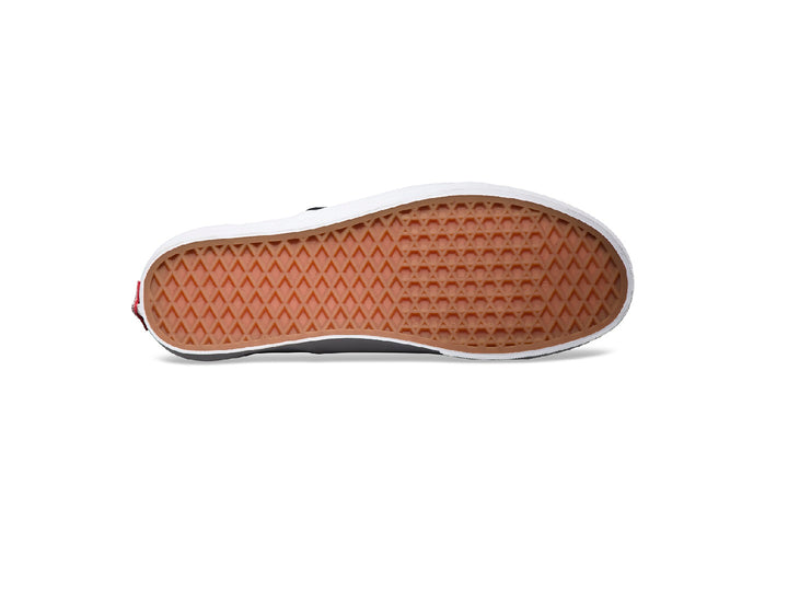 Tenis Vans Classic Slip-On color negro con suela blanca y diseño sin cordones.