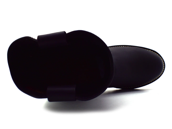 Bota de cuero color negro estilo western con acabado mate y suela gruesa sobre fondo blanco.