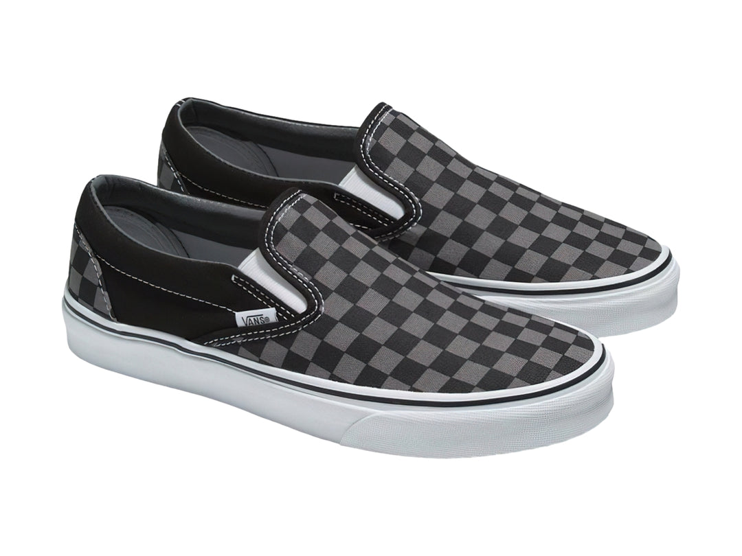 Tenis Vans Classic Slip-On con estampado de cuadros en color negro y gris con suela blanca.