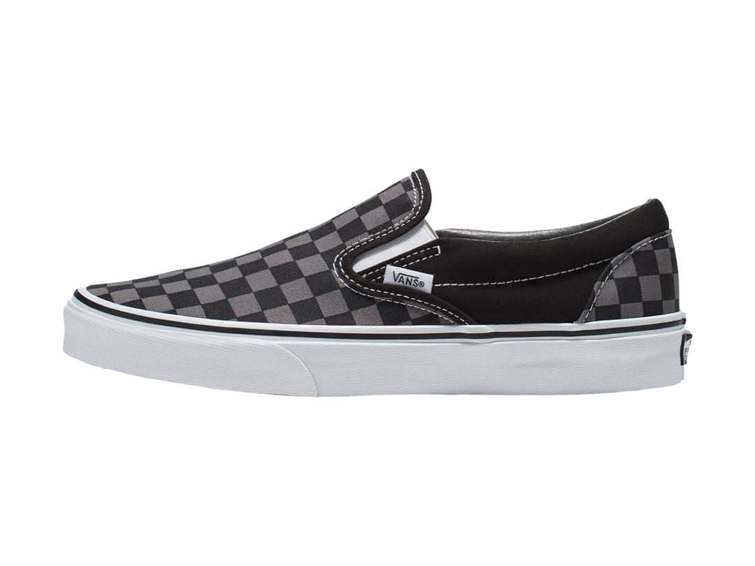Tenis Vans Classic Slip-On con estampado de cuadros en color negro y gris con suela blanca.