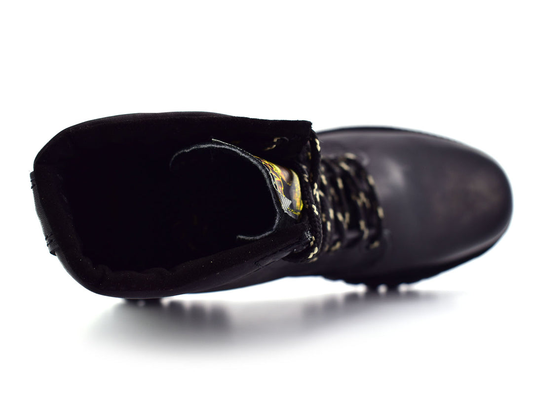 Botas negras de caña media con cordones y suela dentada sobre fondo blanco.