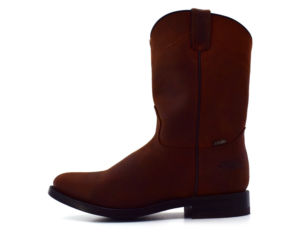 Bota estilo vaquero en color café mate con suela negra, vista lateral sobre fondo blanco.
