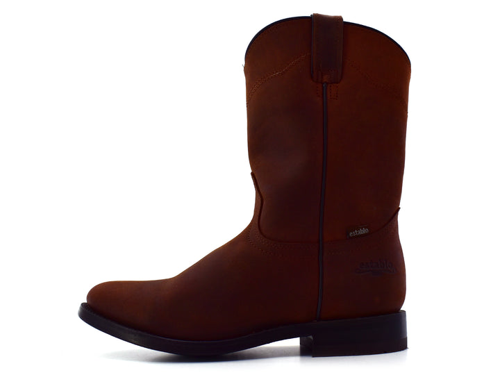 Bota estilo vaquero en color café mate con suela negra, vista lateral sobre fondo blanco.