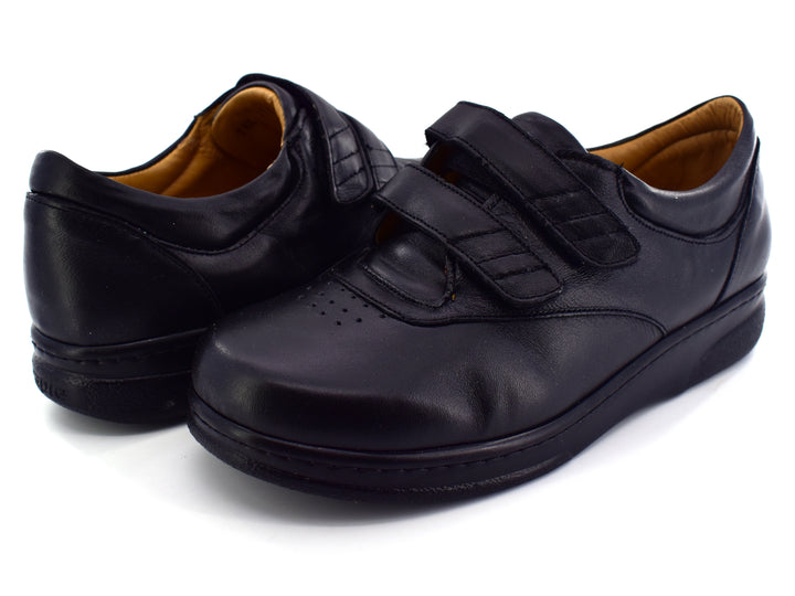 Par de zapatos terapéuticos color negro para hombre con cierre de doble correa de velcro y suela plana.