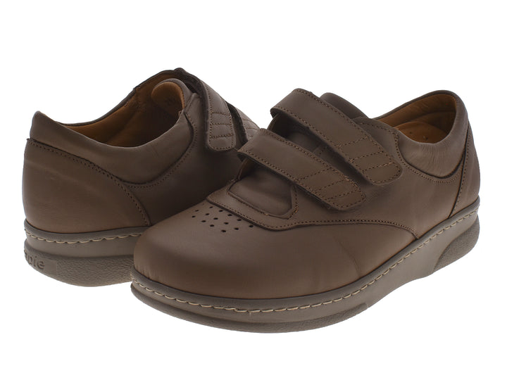 Par de zapatos planos color taupe con cierre de velcro y costuras blancas decorativas.