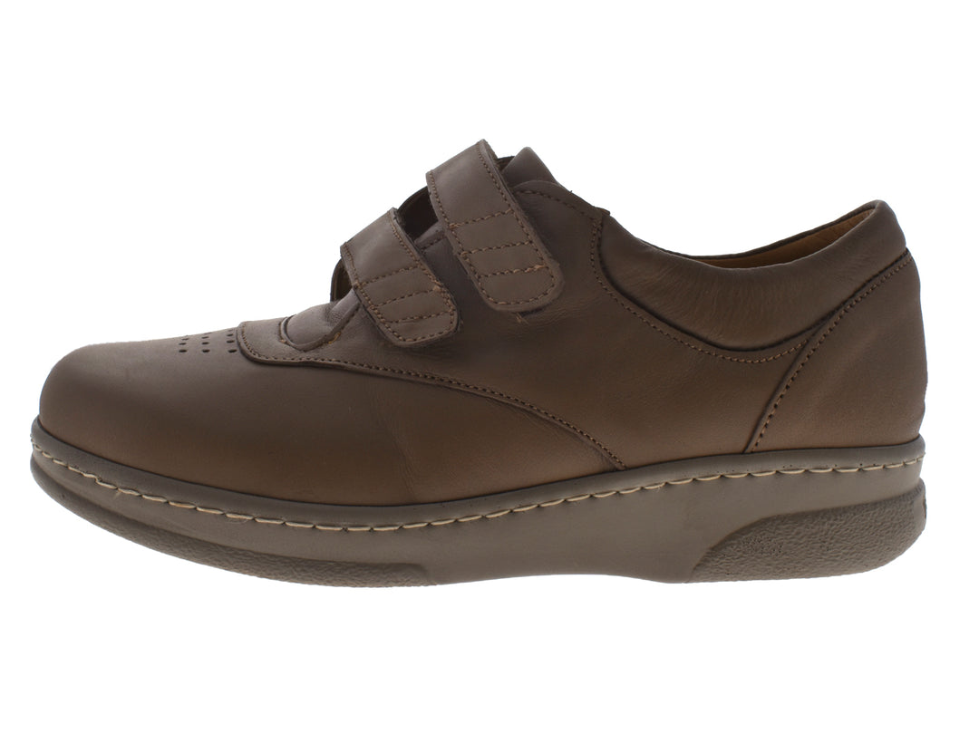Par de zapatos planos color taupe con cierre de velcro y costuras blancas decorativas.