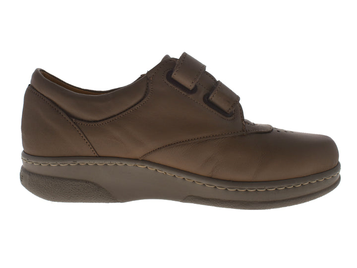 Par de zapatos planos color taupe con cierre de velcro y costuras blancas decorativas.