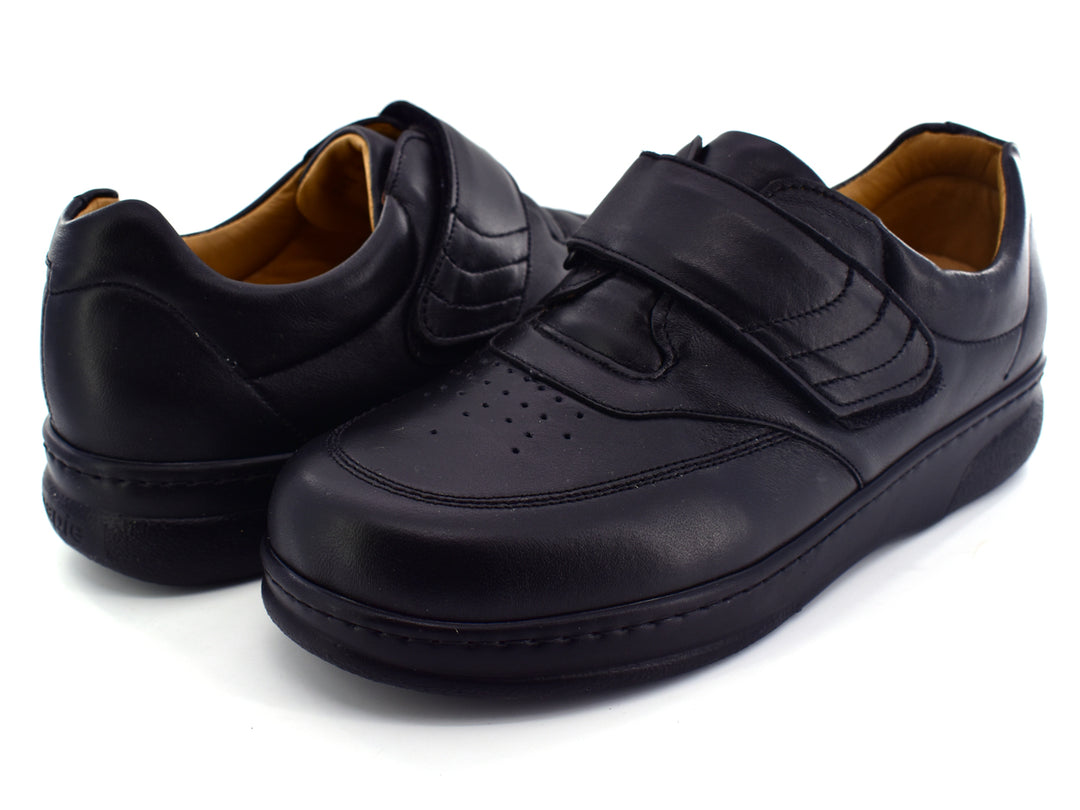 Par de zapatos negros para Niño con correa de velcro y acabado liso.