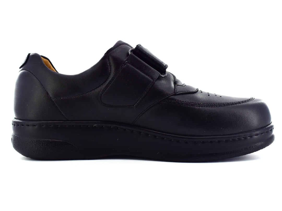 Par de zapatos negros para Niño con correa de velcro y acabado liso.