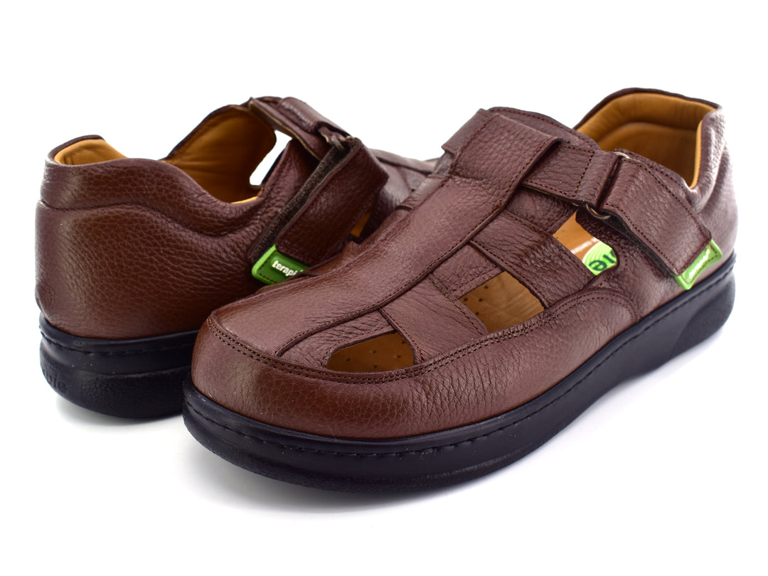 Par de sandalias color café de cuero con suela negra y cierre de velcro.