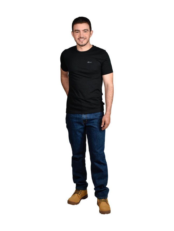 Hombre vistiendo pantalones jeans OGGI de color azul oscuro y tenis blancos sobre fondo blanco.