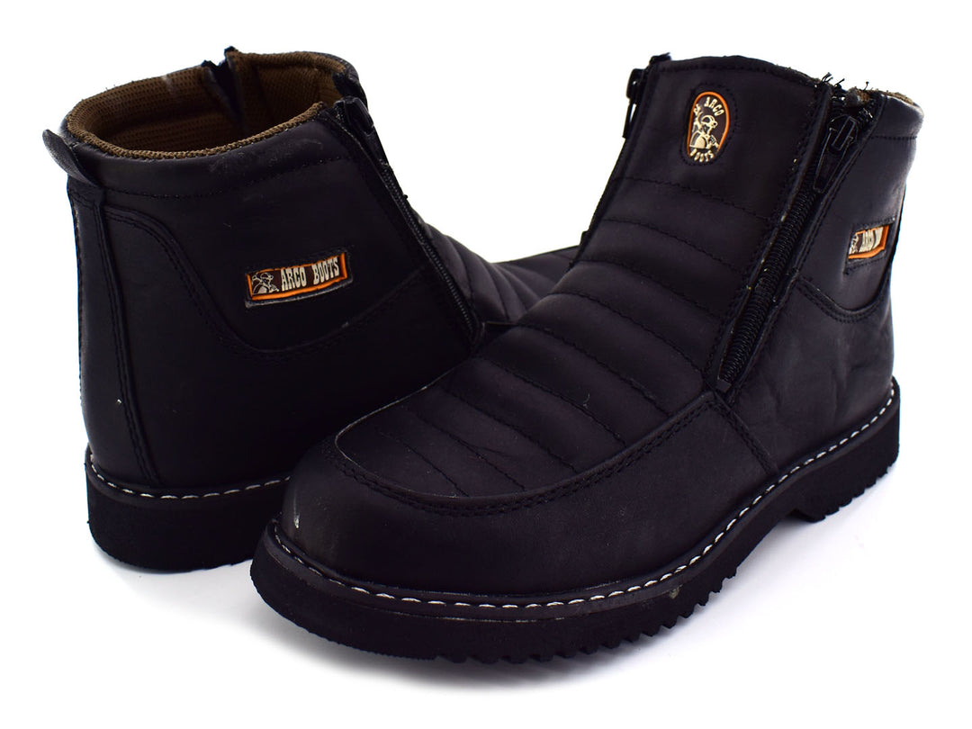 Botas negras de cuero napa para niño con cierre lateral y suela dentada sobre fondo blanco.