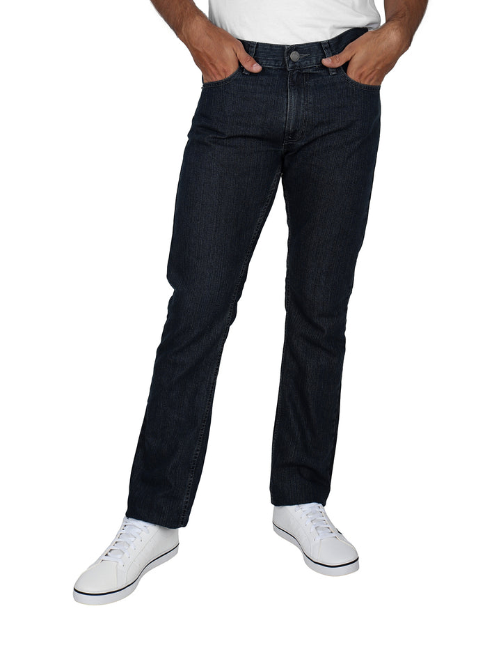 Hombre vistiendo pantalones OGGI Vaxter Epic en color carbon con tenis blancos sobre fondo blanco.