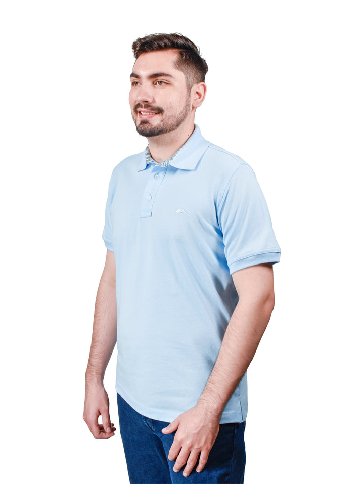 Hombre vistiendo playera polo color cielo de la marca White Peak.