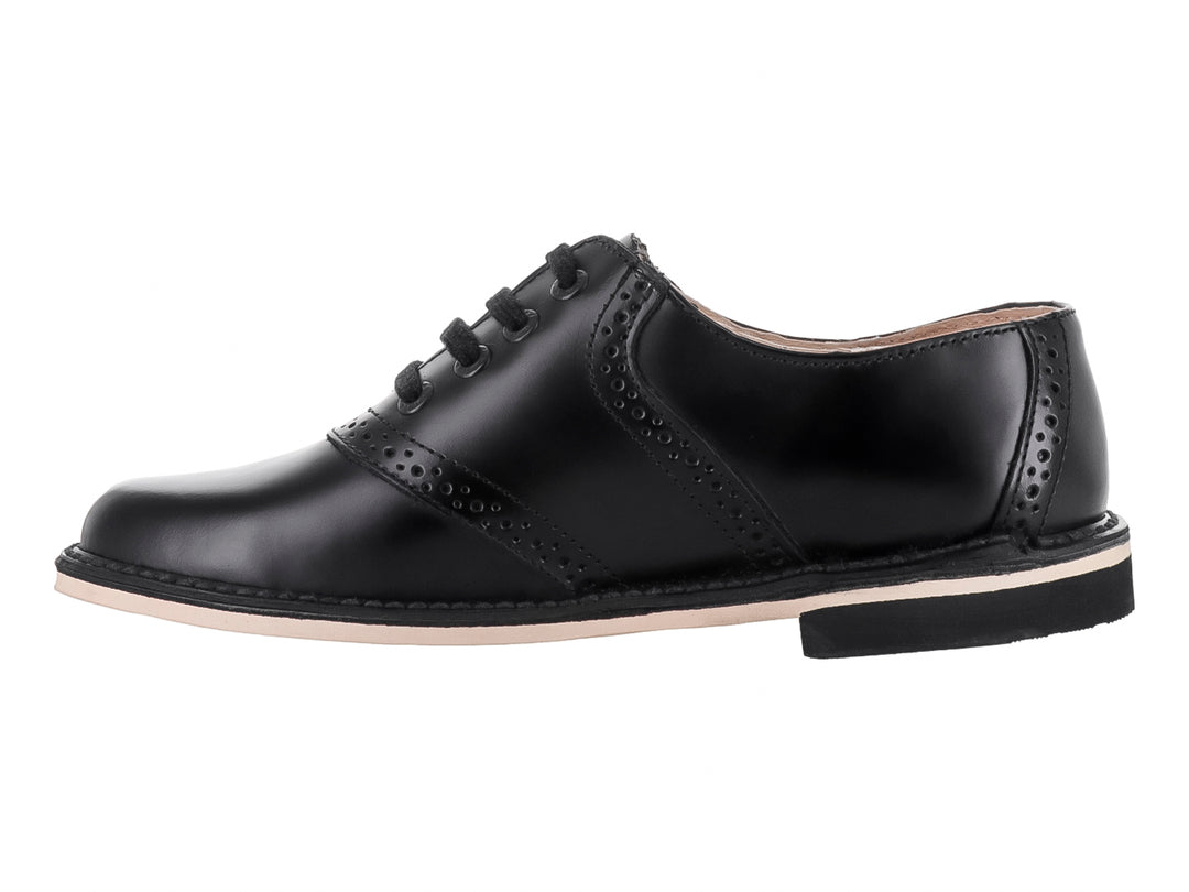 Zapato formal negro de cuero para niño con detalles perforados y suela blanca.