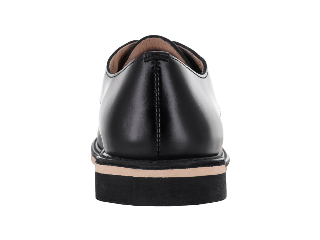 Zapato escolar negro de cuero para niño con cordones y suela blanca y negra.