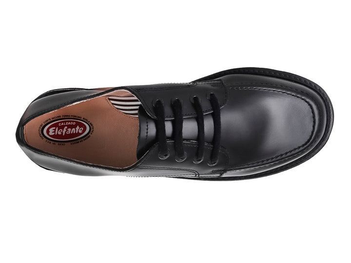 Zapato escolar negro de cuero para niño con cordones y suela blanca y negra.