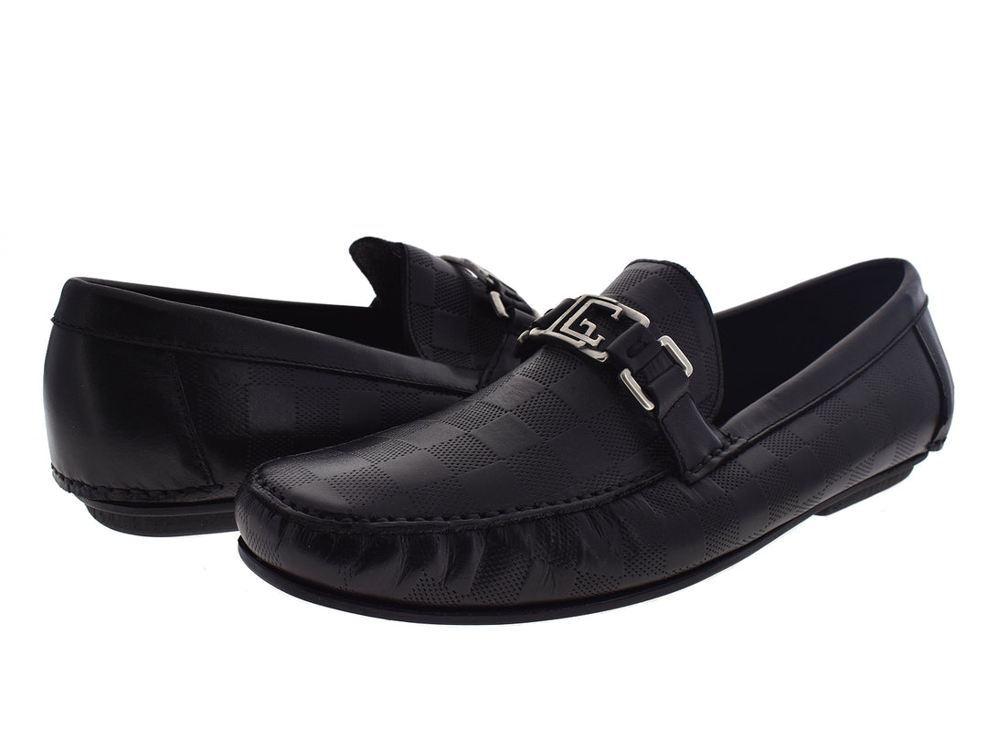 Par de mocasines negros de cuero para hombre con hebilla plateada decorativa.