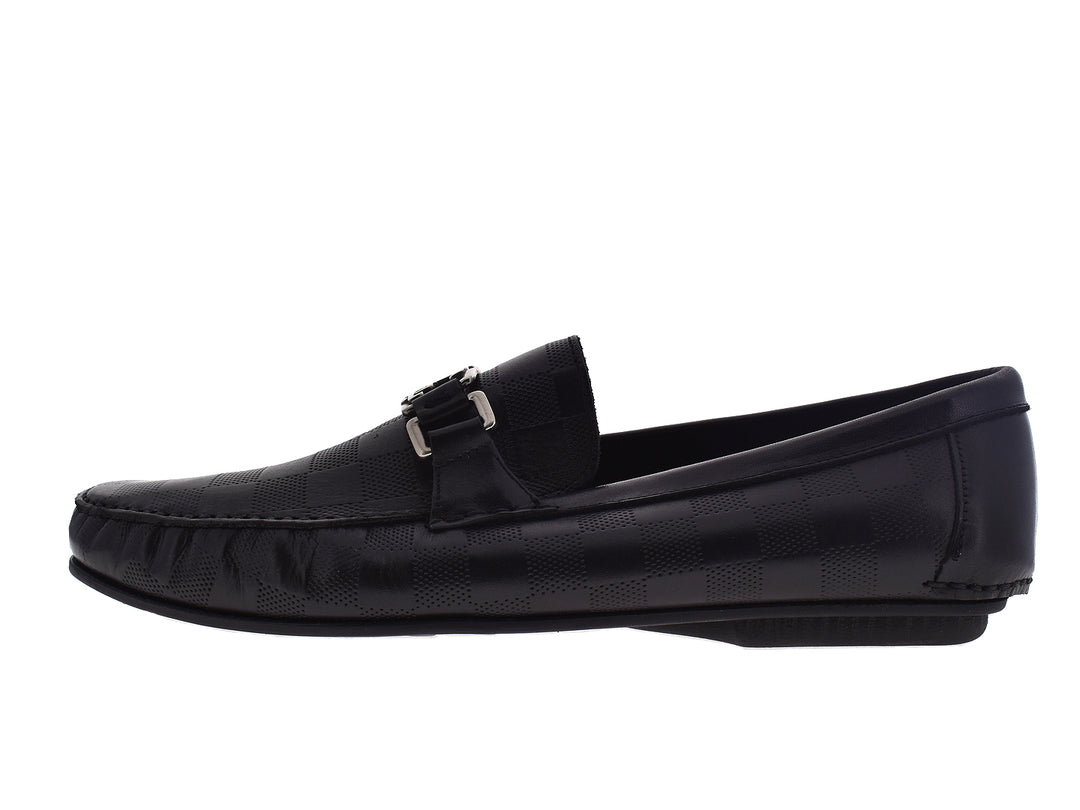 Par de mocasines negros de cuero para hombre con hebilla plateada decorativa.