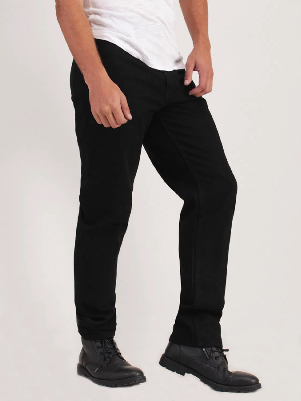 Hombre vistiendo jeans negros de corte recto con camiseta blanca y zapatos negros.