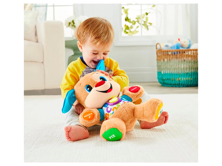 Perro de peluche educativo Fisher-Price en su empaque, con colores brillantes y botones interactivos.