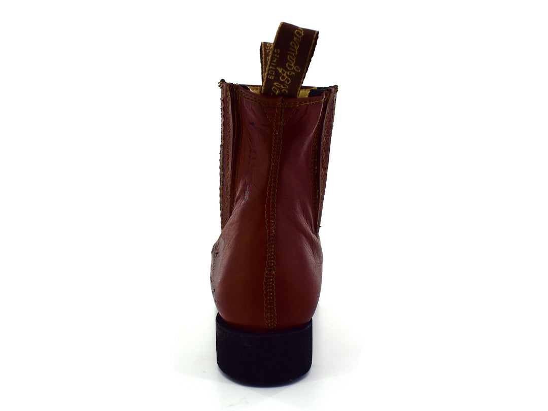Bota estilo Chelsea de cuero color habana con paneles elásticos laterales y suela negra.