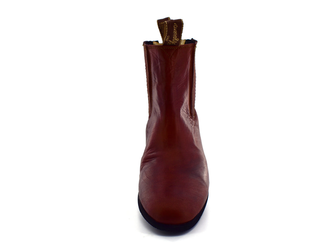 Bota estilo Chelsea de cuero color habana con paneles elásticos laterales y suela negra.