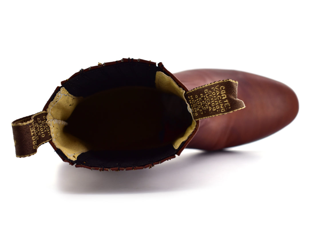 Bota estilo Chelsea de cuero color habana con paneles elásticos laterales y suela negra.
