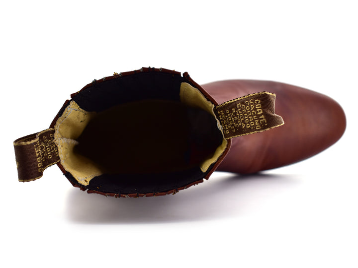 Bota estilo Chelsea de cuero color habana con paneles elásticos laterales y suela negra.