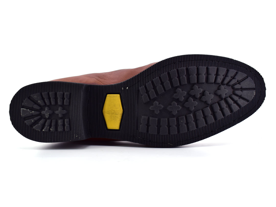Bota estilo Chelsea de cuero color habana con paneles elásticos laterales y suela negra.