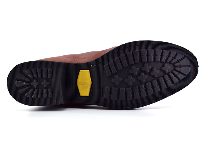 Bota estilo Chelsea de cuero color habana con paneles elásticos laterales y suela negra.