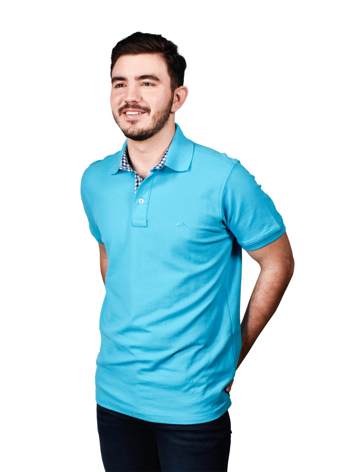 Hombre vistiendo una playera polo de color turquesa con cuello y botones.