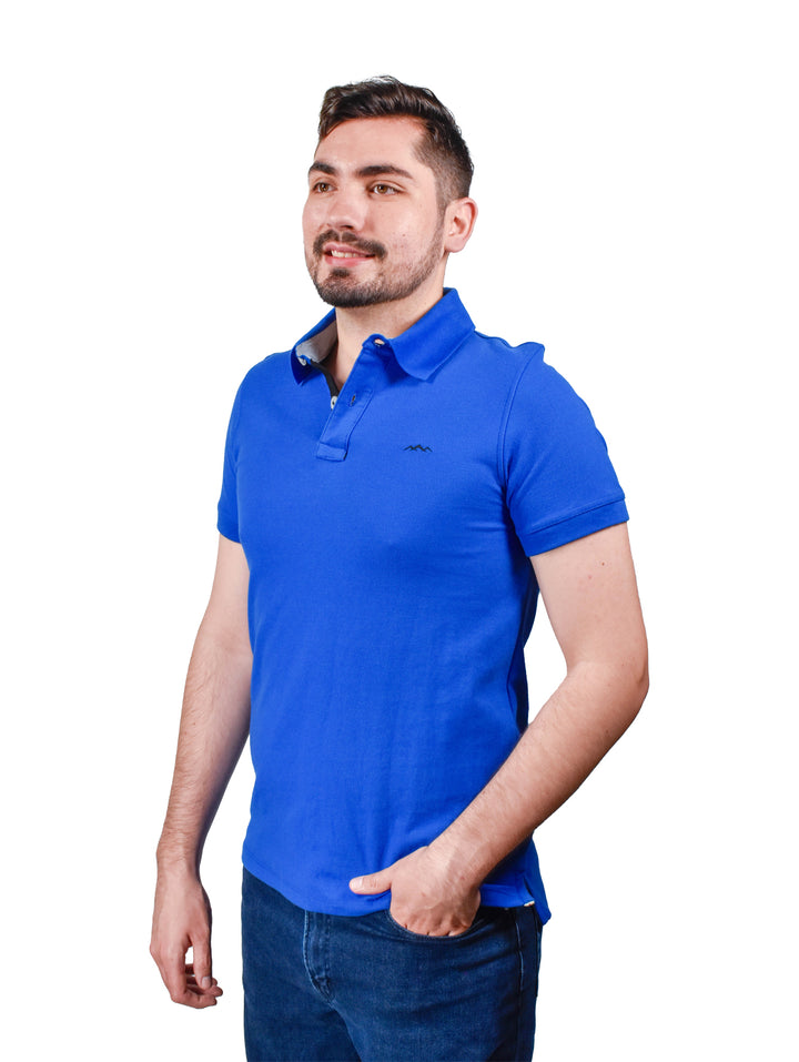 Hombre vistiendo playera polo color azul rey de manga corta.