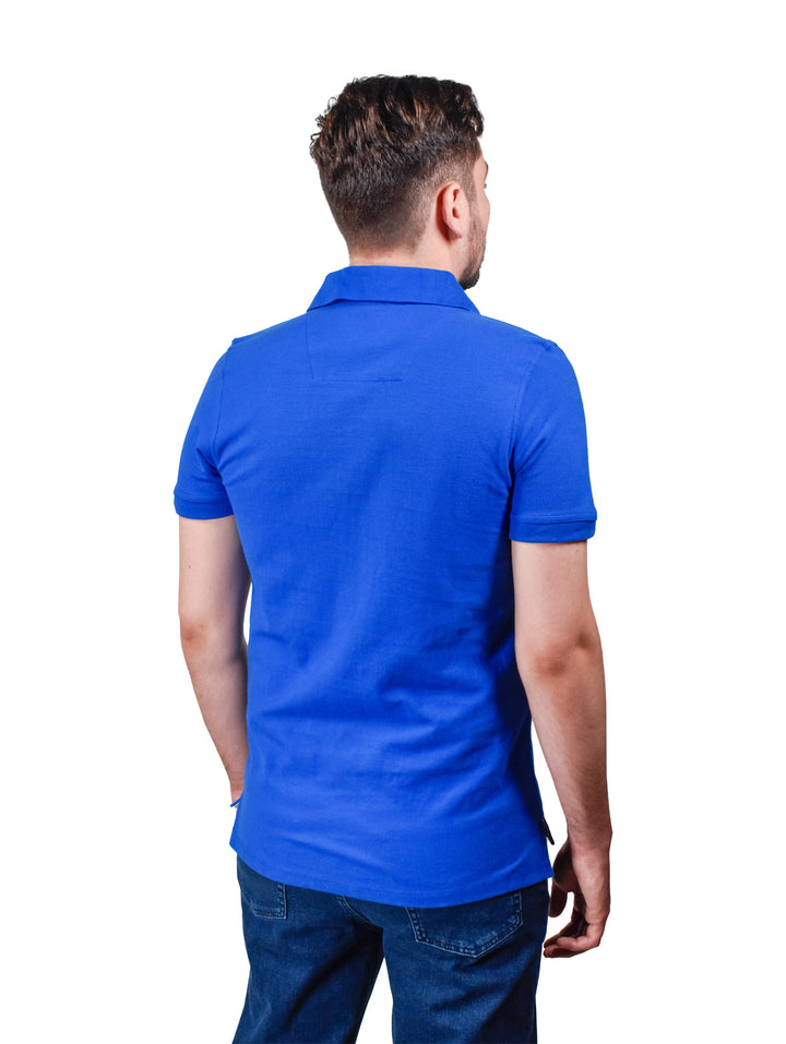 Hombre vistiendo playera polo color azul rey de manga corta.
