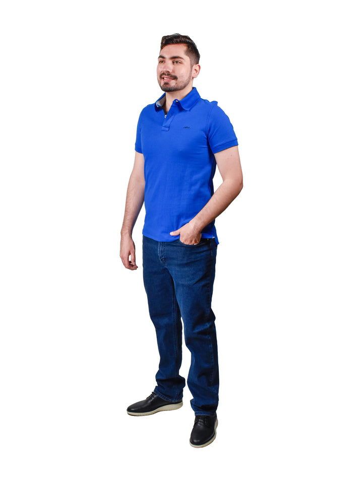 Hombre vistiendo playera polo color azul rey de manga corta.