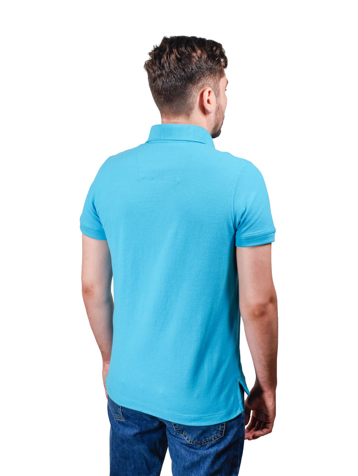 Hombre vistiendo una playera polo color turquesa de manga corta con cuello y botones.
