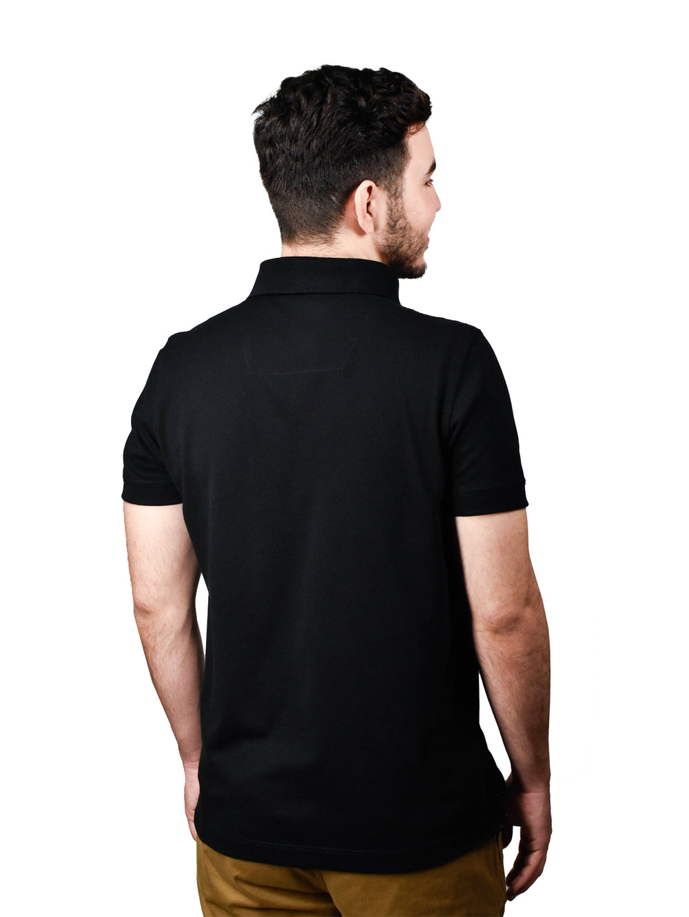 Hombre vistiendo una playera polo color negro de manga corta con cuello y botones.