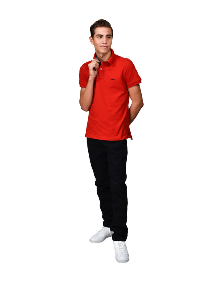 Hombre vistiendo una playera polo de color rojo con cuello y botones.