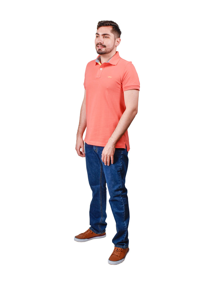 Hombre vistiendo una playera polo color coral de manga corta con cuello.