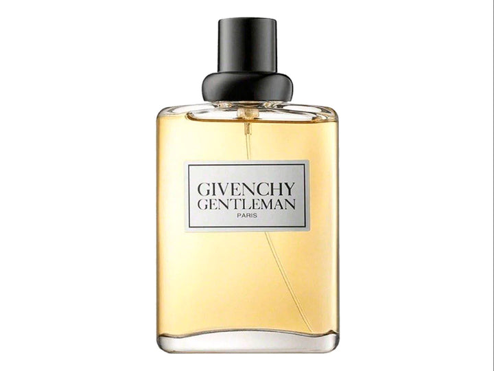 Perfume Givenchy Gentleman con botella de vidrio transparente y líquido dorado junto a su caja negra.
