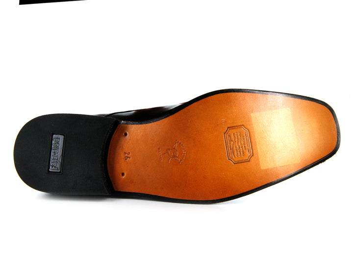 Par de zapatos formales de cuero negro con cordones sobre fondo blanco.